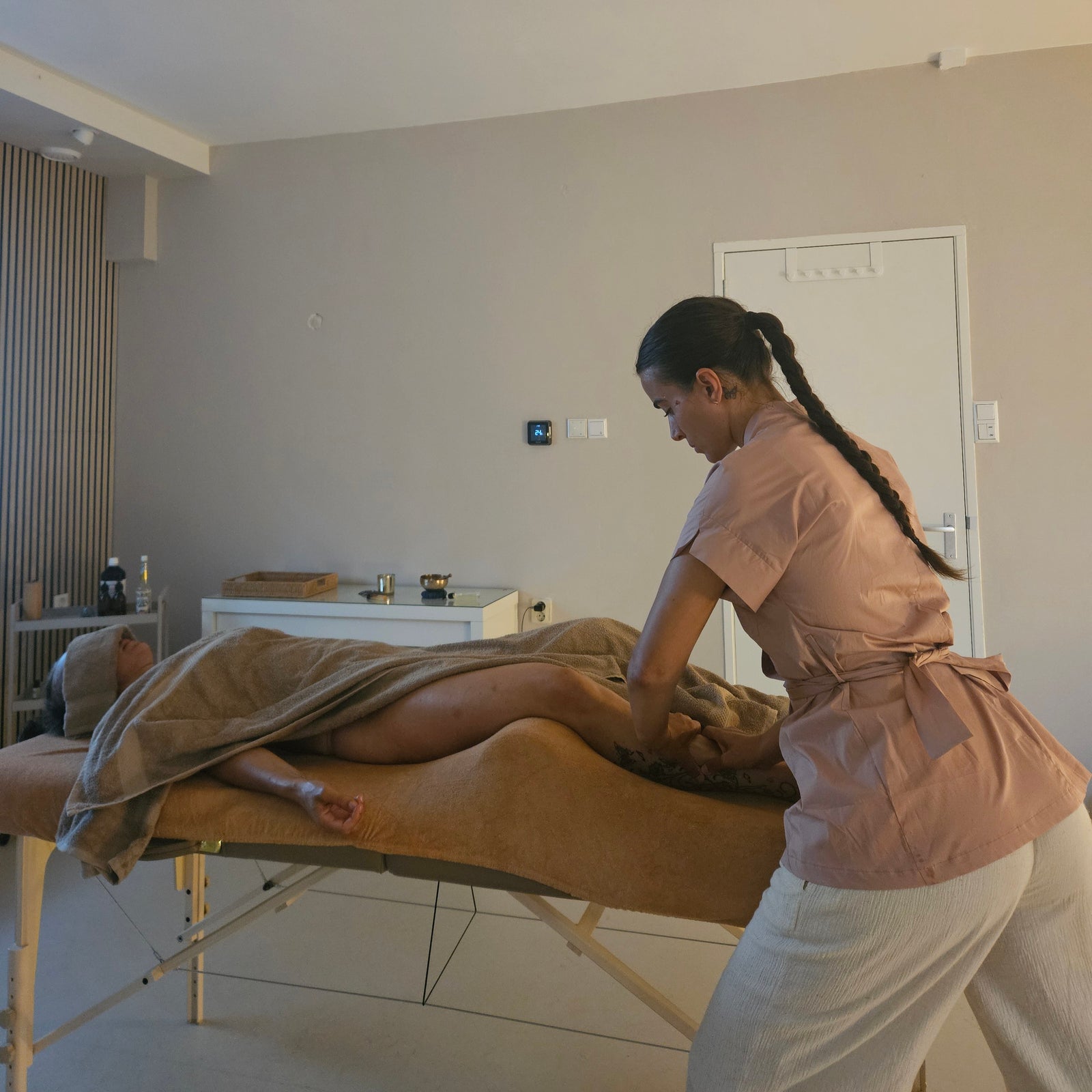 Een massage op de massagetafel, de cliënt ligt op de buik